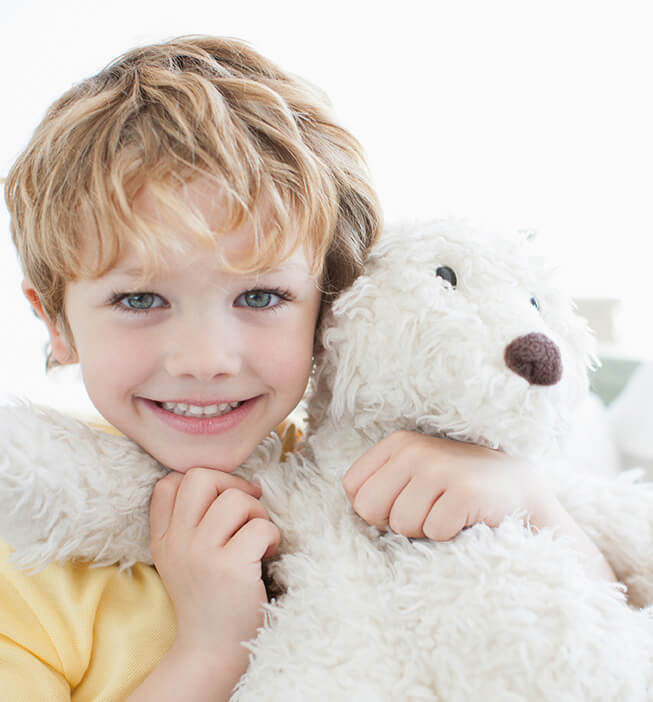 little boy hugging his teddy bear