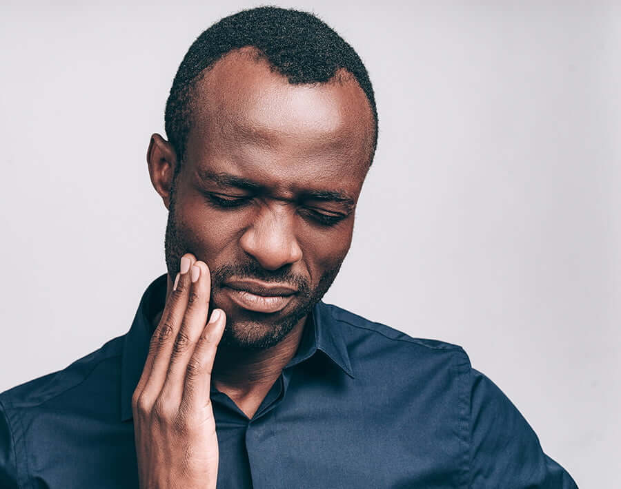 man holding jaw in pain